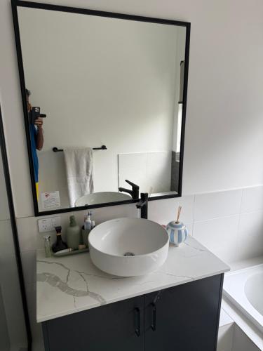 a bathroom with a sink and a large mirror at Radhika Kutir in Perth