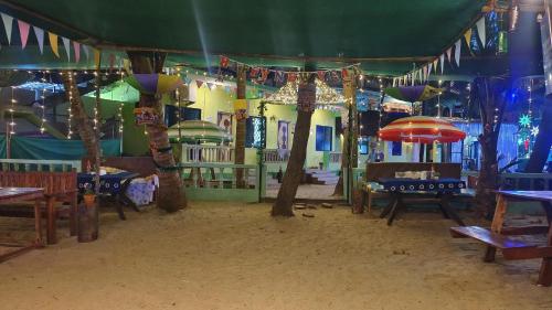 uma área de recreação infantil com mesas e guarda-sóis em Oceanview Nohas Guesthouse Arambol em Arambol