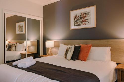 a bedroom with a large bed and two mirrors at Port Stephens Koala Sanctuary in One Mile