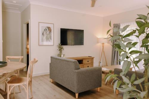 a living room with a table and a chair and a couch at Port Stephens Koala Sanctuary in One Mile