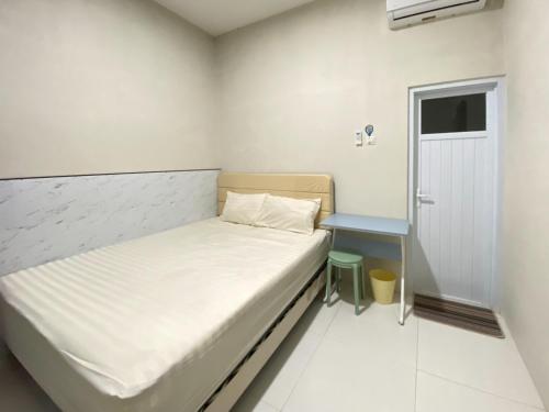 a small bedroom with a bed and a small table at Modern Stay near Roxy Mall Jember RedPartner in Panti