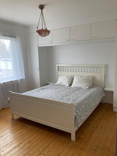 a white bed in a white bedroom with a white ceiling at Idyllic vacation home with lakeview in Grönskåra