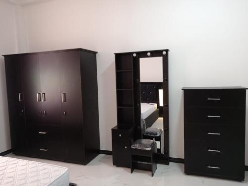 a bedroom with a black dresser and a mirror at Biyagama Highway view Luxury House in Kelaniya