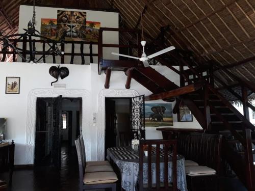 a dining room with a table and a ceiling at Artistic Dreamsace 4Br Villa Near Diani Beach in Kwale