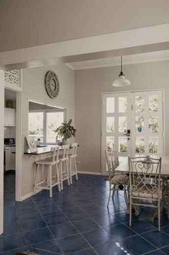 a kitchen and dining room with a table and chairs at The Little River Cottage - Riverfront Retreat in Murwillumbah