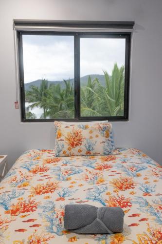 a bedroom with a bed with a window at Hichinbrook Lodge, waterfront in Cardwell