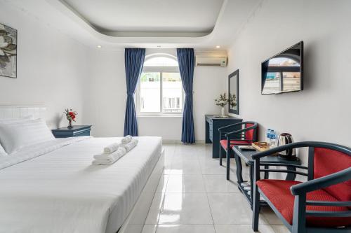 a hotel room with two beds and a table and chairs at La Casona Retreat in Ho Chi Minh City