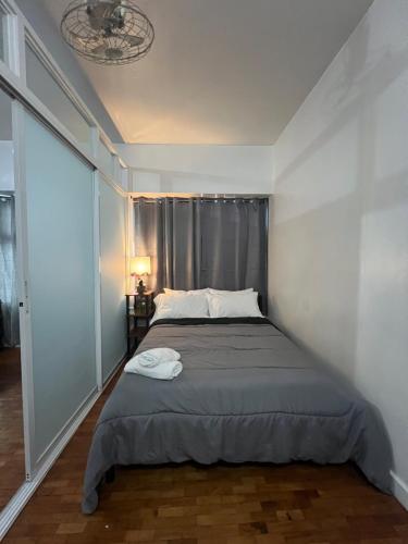 ein Bett in einem Zimmer mit einem großen Fenster in der Unterkunft Robinson's Place Residences, in Manila