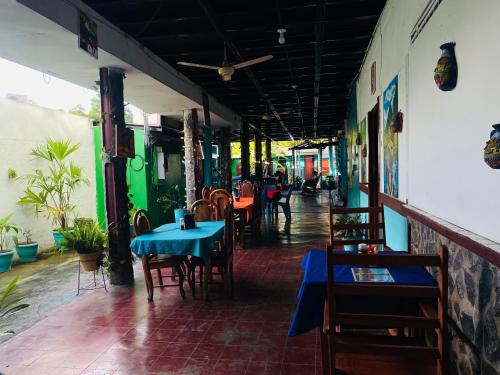 a restaurant with tables and chairs and a blue table at Hotel My Isla Bonita in Moyogalpa