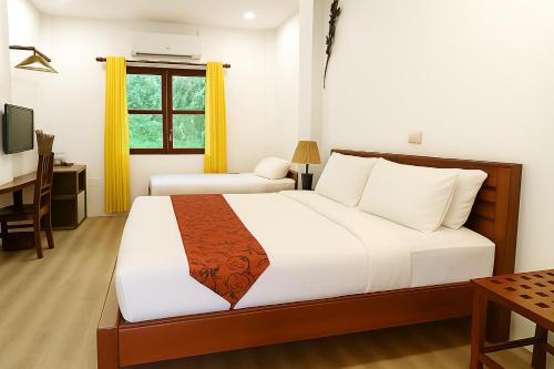 een slaapkamer met een groot bed en een bureau bij Paradise K Forest Hotel in Siem Reap