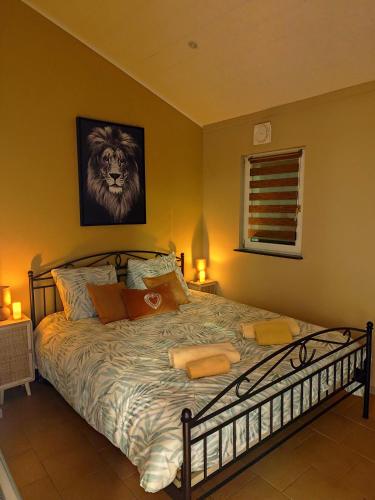 a bedroom with a bed with a lion picture on the wall at Le Rensy in Ferrières