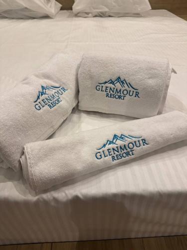a pile of towels sitting on a bed at Glenmour Resort Ella in Ella