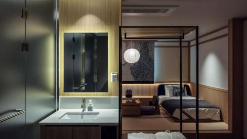 a bedroom with a bed and a sink and a mirror at Aank Resort & Spa Busan Haeundae in Busan