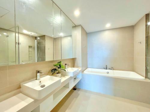 a bathroom with two sinks and a tub and a mirror at The Sóng 5 Star Apartment 5 Star Vung Tau - Căn Hộ Du Lịch 5 Sao Cạnh Biển in Vung Tau