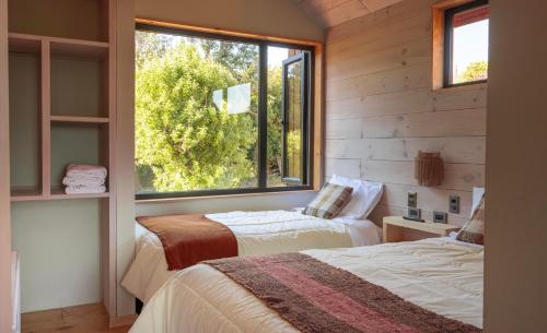 two beds in a room with a window at Casas Arco Jardin in Castro