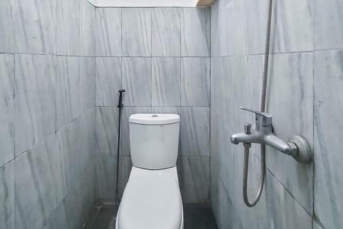 Un baño con inodoro blanco y ducha. en Nay Guesthouse near UMS Mitra RedDoorz, en Colomadu
