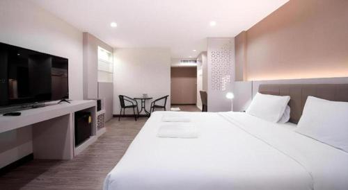 um quarto de hotel com uma cama grande e uma televisão em The Y House em Chiang Mai