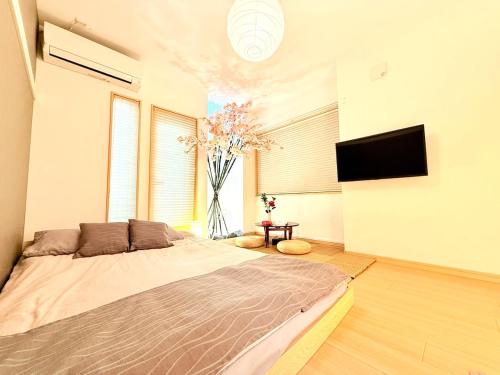 a bedroom with a large bed and a tv at AYA Funabashi#104 Enjoy the cherry blossoms in full bloom, Tatami experience, Funabashi station near by, Many restaurants & shops, Kid, Long term, Direct airport access, Messe, Disney, Cozy in Funabashi