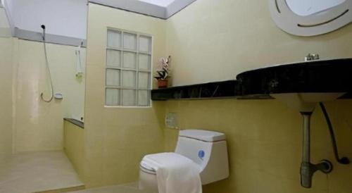 um banheiro com vaso sanitário, chuveiro e janela em Warina Place Hotel em Ao Nang 
