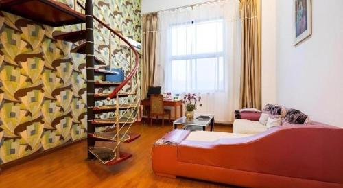 a living room with a red couch and a spiral staircase at GreenTree Inn Jiangsu Wuxi Meiyuan Kaiyuan Temple Subway Master Station Express Hotel in Wuxi