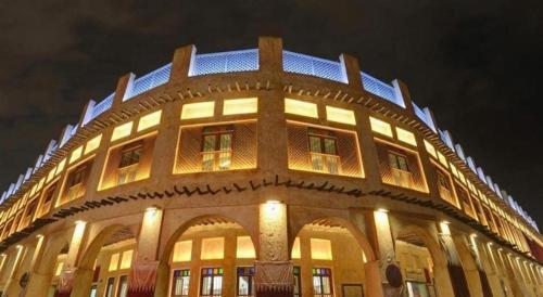 Un edificio con luces en la parte superior por la noche. en Sovereign Hotel - Marriage Certificate Required, en Doha
