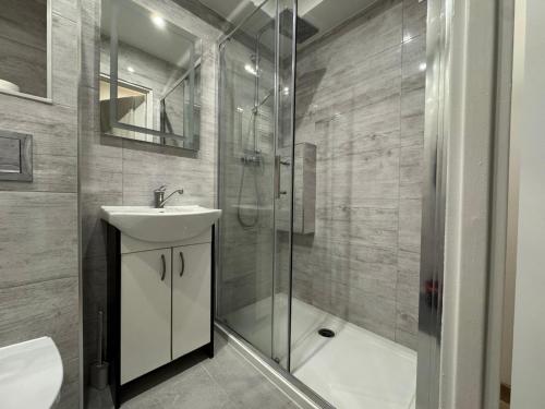 Un baño con ducha, lavabo e inodoro. en SAS Militaria dla 2 par 2 pokoje 4 osoby, en Borne Sulinowo