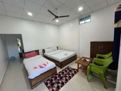 Kohuwa Resort في Jyoti Gaon: غرفة بسريرين وطاولة وكرسي