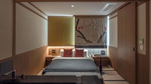 a bedroom with a bed and a painting on the wall at Aank Resort & Spa Busan Haeundae in Busan