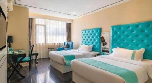 楽山市にあるXana Lite Leshan Haochi Street Branchのベッド2台と机があるホテルの部屋