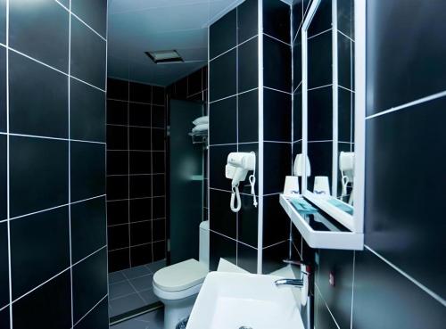 a bathroom with a toilet and a sink and a mirror at PAI Hotel Zhuhai Doumen Daxin Xinduhui Bus Terminal in Towmoon