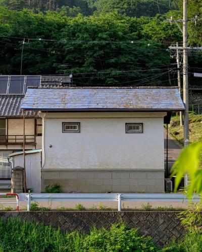 a small white building with a blue roof at The Bath and Bed Sakuho in Saku