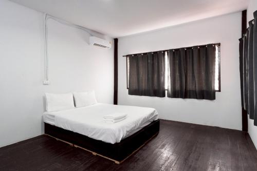a bedroom with a bed with white sheets and a window at XX Mitr Khaosan Bangkok in Bangkok