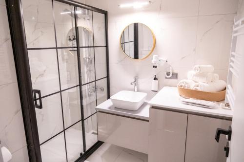 een witte badkamer met douche en wastafel bij BL Karakum Suites in Sinop