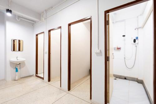 a row of glass doors in a room with a sink at XX Mitr Khaosan Bangkok in Bangkok