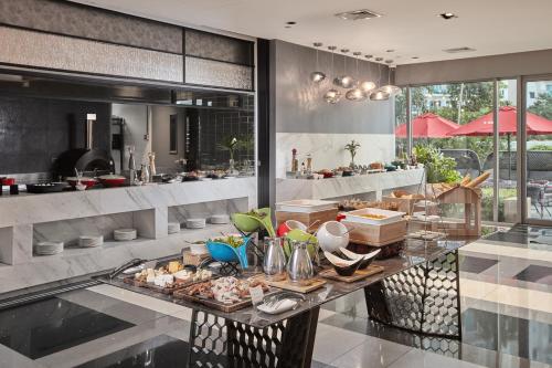 un buffet en un restaurante con comida en una mesa en Cleo Suites at Novotel Hotel Residences near Makati, en Manila