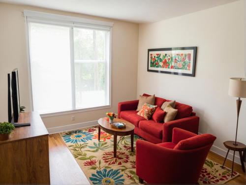 a living room with a red couch and a table at Boutique KTown Stays With Breathtaking Rooftop Views in Los Angeles