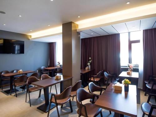 a restaurant with tables and chairs and a window at James Joyce Coffetel Xuzhou Feng County Huadi Street in Feng