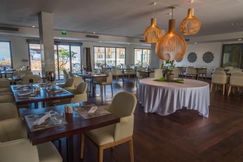 uma sala de jantar com mesas e cadeiras num restaurante em Le Battant Des Lames em Saint-Pierre