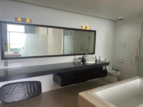 a bathroom with a sink and a mirror and a toilet at Ocean Vista Resort Sealink Phan Thiet in Ấp Phú Tịnh (2)