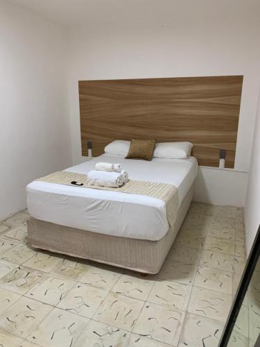 a bedroom with a large bed with a wooden headboard at Casa Palmeras in Cancún