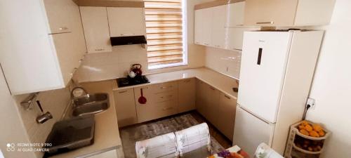 eine kleine Küche mit einem weißen Kühlschrank und einem Fenster in der Unterkunft Beloved Home in Çilǝgir