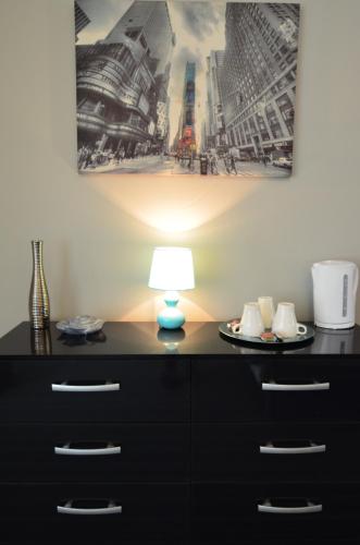 a lamp sitting on a dresser in a room at Old Trafford Guest House in Manchester