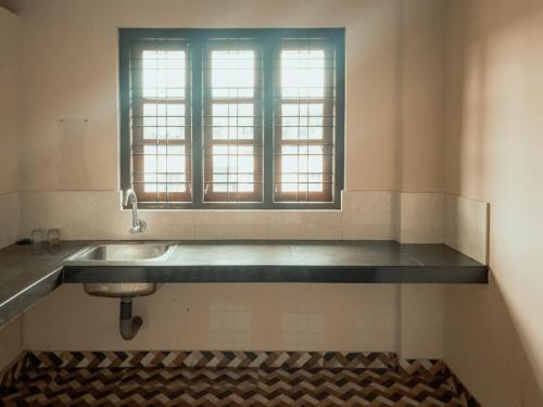 Fine Homes في كالباتّا: حمام مع حوض ونافذة