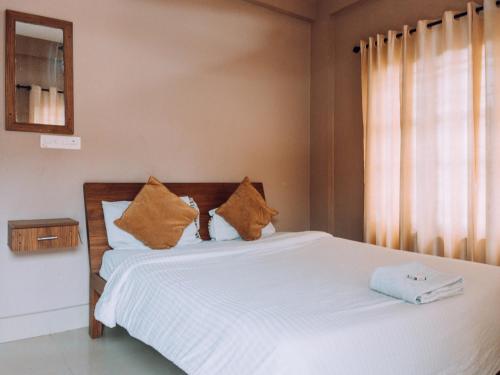 Fine Homes في كالباتّا: غرفة نوم بها سرير بملاءات بيضاء ونافذة