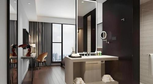 a bathroom with a sink and a large mirror at Gya Hotel Hangzhou Yuhang District Smart Town Wanda Plaza in Cangqian