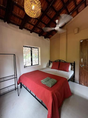 MagdālSolaya Living - Galgibaga - 1 min to the beach的一间卧室配有一张带红色床单和吊灯的床。