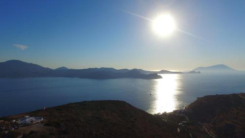 a sun setting over a large body of water at Drougas' Windmill in Plaka Milou