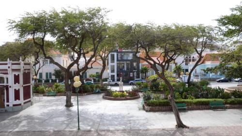 Prassa 3 Boutique Hotel في منديلو: حديقة بها أشجار وكراسي في مدينة