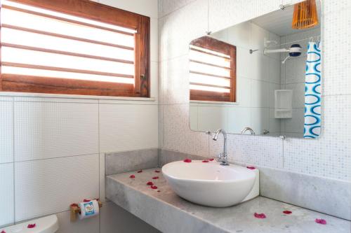 Baño blanco con lavabo y espejo en Cumbuco Kite in Paradise e Hospedaria, en Cumbuco