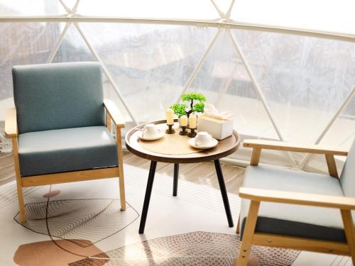 two chairs and a table in a room with a window at L1 Lanta Resort in Ko Lanta